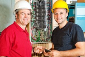 4685123-friendly-master-electrician-and-apprentice-working-on-breaker-panel